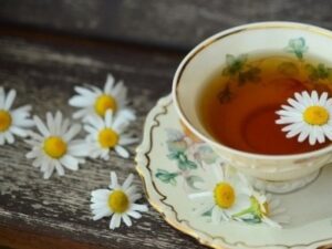 Herbal tea made from herbs for viruses like echinacea, elderberry, and sage by Health Embassy in a clear cup with fresh herbs around.
