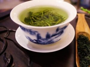 A cup of Health Embassy tea showcasing the rich colors of green tea vs black tea, highlighting their natural freshness and quality.