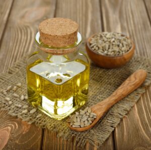 A glass bottle of natural cold pressed oils with seeds in the background – Health Embassy