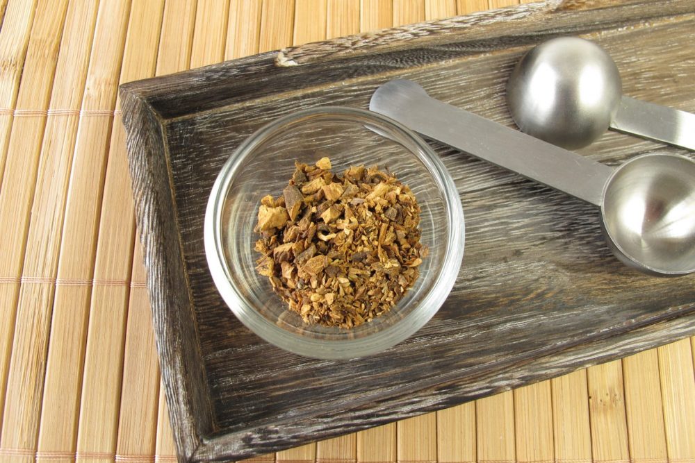 Superfoods and Herbs. Dried tea in a glass bowl. Wooden tray.