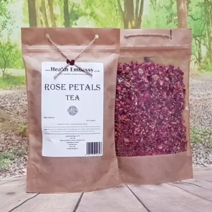 Front view of Health Embassy Rose Petals Tea package with string against lush forest backdrop