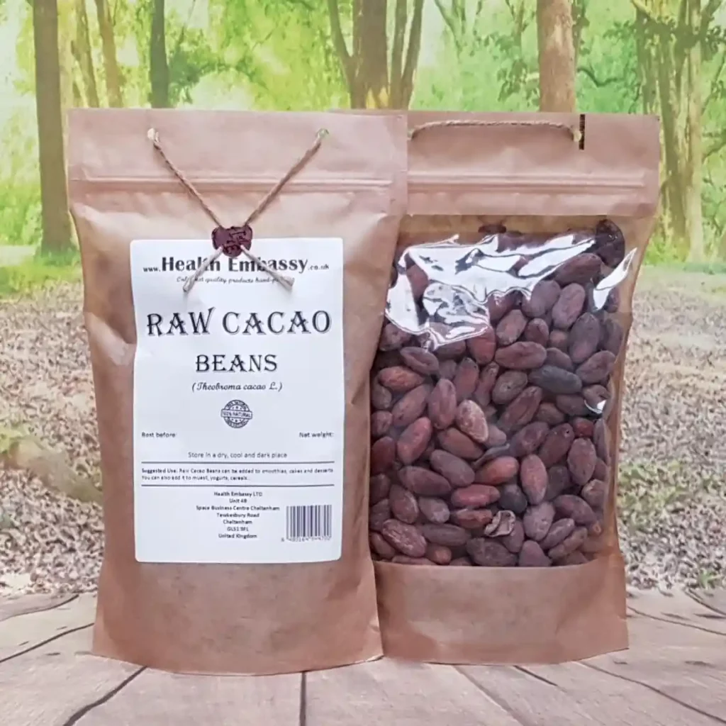 Raw cacao beans in a paper bag on a wooden surface with a natural green background, by Health Embassy